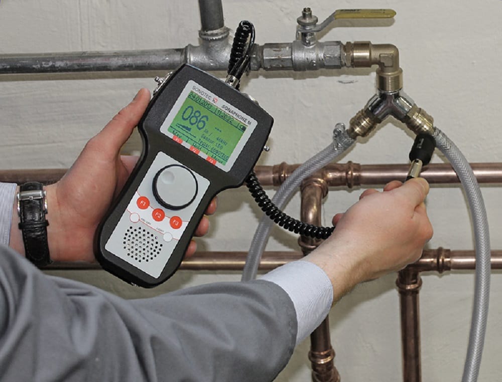 Plumber testing pipes with electronic leak detection equipment in Rialto
