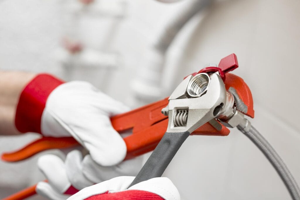 Plumber holding pipe wrenches for an emergency repair in Rialto