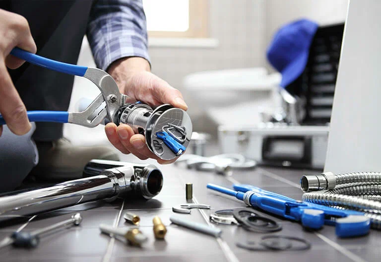 Technician repairing a plumbing fixture with professional tools in Rialto