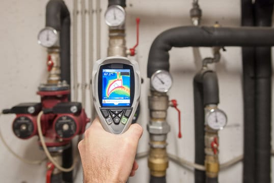 Plumber using a thermal imaging camera to inspect pipes in Rialto