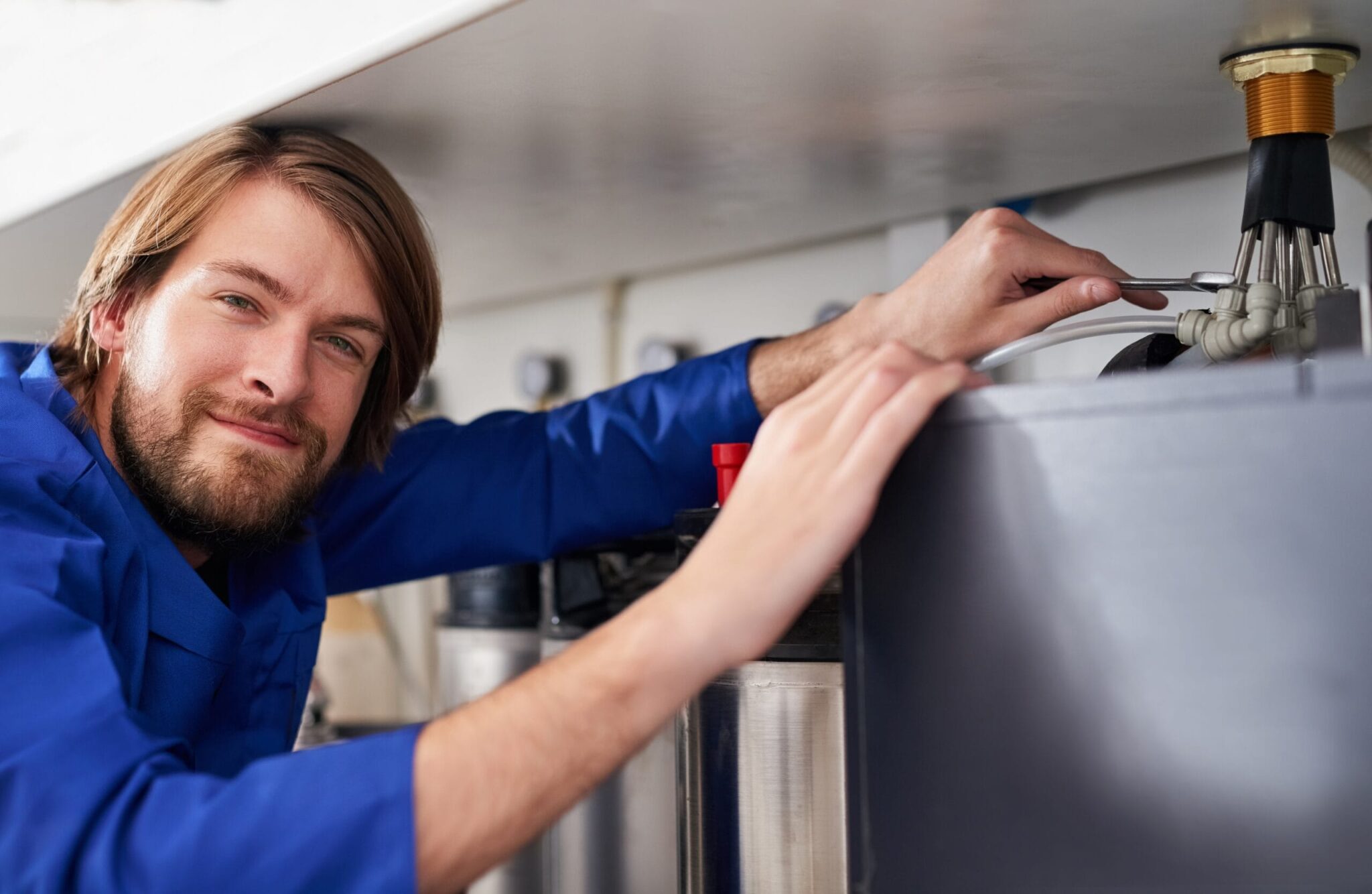Technician servicing a residential water heater tank in Rialto